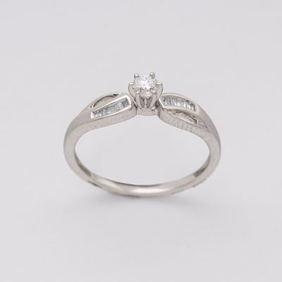 Sortija en oro blanco con diamante central talla brillante engastado en garras custodiado por 