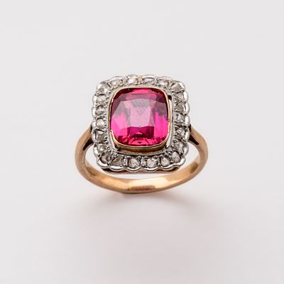 Sortija en oro y vistas en platino con rub&iacute; central talla coj&iacute;n y orla de diamantes talla rosa. 