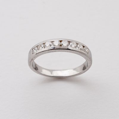 Sortija media alianza en oro blanco con diamantes talla brillante engastados en carril. Peso 