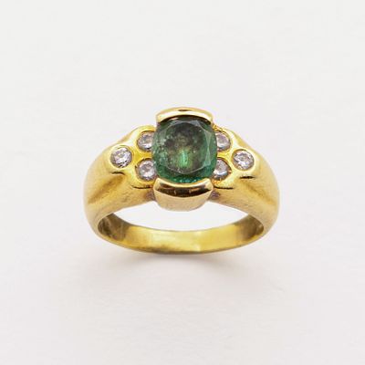 Sortija en oro con esmeralda talla oval custodiada por tr&iacute;os de diamantes talla brillante. Peso 