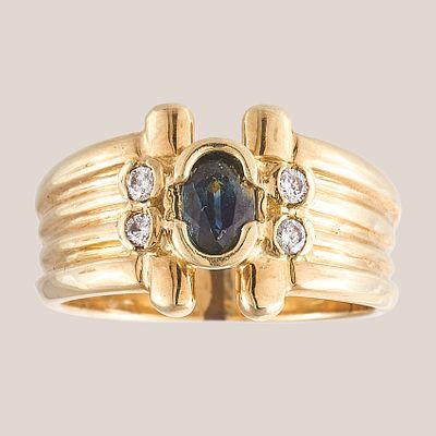 Sortija gallonada en oro con zafiro azul talla oval custodiado por pareja de diamantes talla 