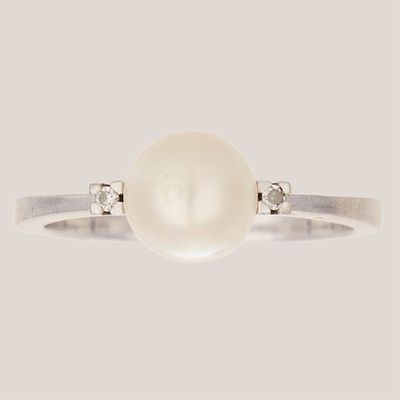 Sortija en oro blanco con perla cultivada de 7 mm. custodiada por diamantes talla brillante. 
