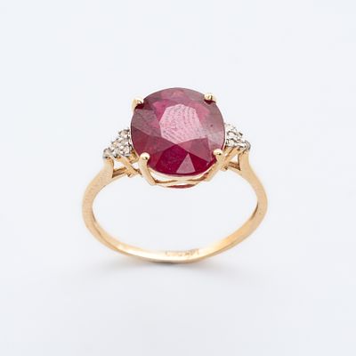 Sortija en oro 14K con rub&iacute; talla oval custodiado por tri&aacute;ngulos de pav&eacute; de diamantes talla 