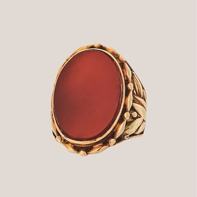 Sortija sello en oro con &aacute;gata cornalina oval de 20,5 x 15,5 mm. y brazos decorados con motivos 