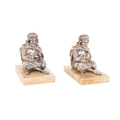 Pareja de sujetalibros con representaci&oacute;n de dos personajes &aacute;rabes sedentes en metal plateado y 