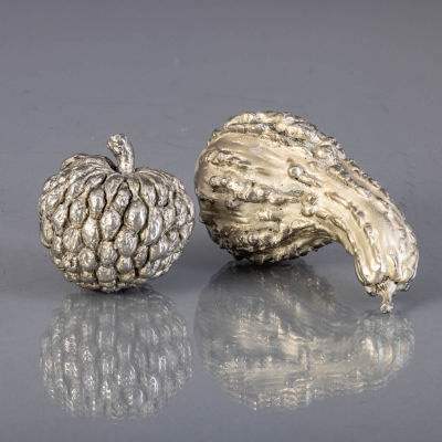 DOIS FRUTOS. Em metal prateado, decora&ccedil;&atilde;o relevada. Sinais de uso. Dim.: 7,5 e 9x17 cm.