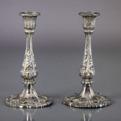 PAR DE CASTI&Ccedil;AIS. Em metal prateado, decora&ccedil;&atilde;o relevada com elementos vegetalistas, com 