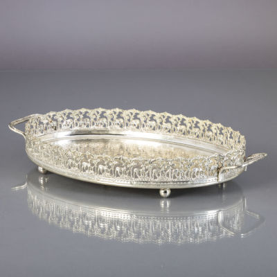 TABULEIRO OVAL DE GRADINHA. Em metal prateado, fundo martelado, gradinha vazada com renas. 