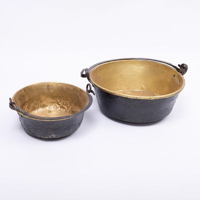 DOIS TACHOS. Em latão, pegas em ferro. Sinais de uso, amolgadelas e um com restauros. Dim.: 16