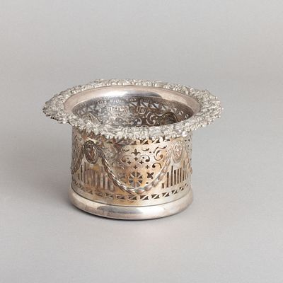 BASE PARA GARRAFA. Em metal prateado, decoração relevada e vazada "Fauce de leão, grinaldas e