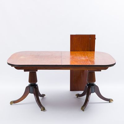 MESA DE JANTAR. Em diferentes madeiras, de dupla coluna torneada e pés com terminais em metal