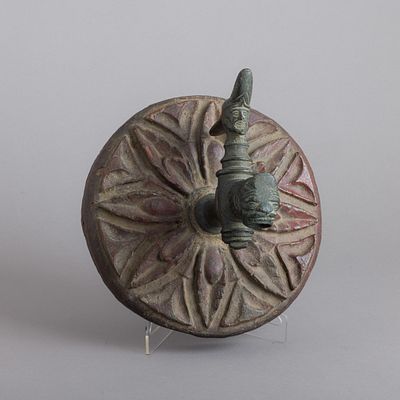 TORNEIRA. Em bronze patinado, decoração relevada com cabeça de homem e de animal, aplicada em 