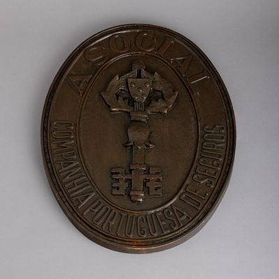 PLACA "A SOCIAL". Em bronze relevado e patinado. Sinais de uso. Dim.: 54x41,5 cm.