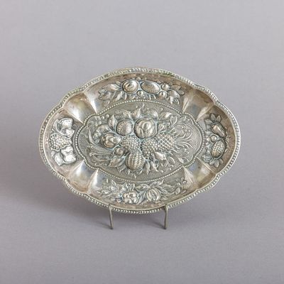 ANELEIRA RECORTADA. Em metal prateado, decoração relevada "frutos", bordo com friso de perlados. 