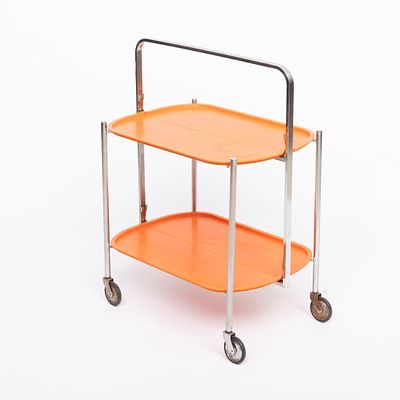 CARRINHO DA CH&Aacute; ARTICULADO. Em metal cromado, tampos em material sint&eacute;tico de cor laranja. 