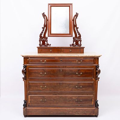 C&Oacute;MODA COM TOUCADOR. Em mogno e folheado a raiz de mogno, com entalhamentos, de quatro gavetas 