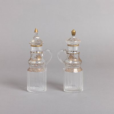 PAR DE GALHETAS. Em vidro facetado decora&ccedil;&atilde;o a dourado "grinaldas e frisos geom&eacute;tricos". Sinais 