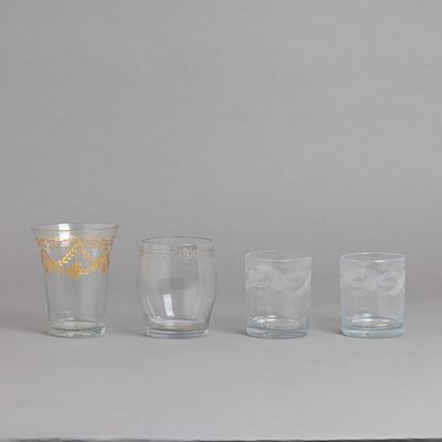 QUATRO COPOS. Em vidro e cristal soprado e moldado, decora&ccedil;&atilde;o gravada a &aacute;cido, um a dourado. 