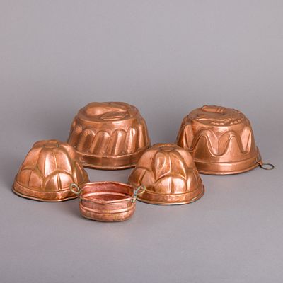 QUATRO FORMAS E PEQUENO RECIPIENTE. Em cobre, formas estanhadas no interior, decora&ccedil;&atilde;o relevada 