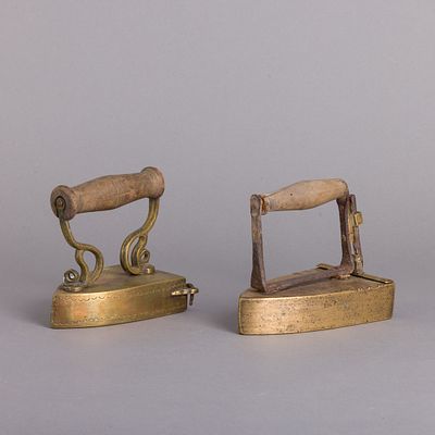 DOIS FERROS DE BRUNIR. Em metal e ferro, pegas em madeira. Com sistema de cunha. Sinais de uso 