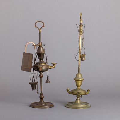 DUAS CANDEIAS DE AZEITE. Em metal amarelo, com quebra-luz e diversos utens&iacute;lios, bases de 