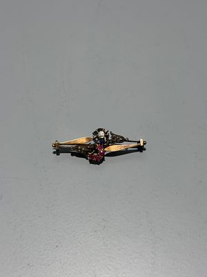 Pregadeira em ouro cravejada com diamantes, safiras e rubis. 
Sem marcas, ao abrigo do 
