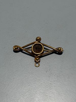 Pendente/alfinete em ouro com moeda ao centro. 
Ouro testado 
Sinais de uso. 
Peso: 10,5 gr