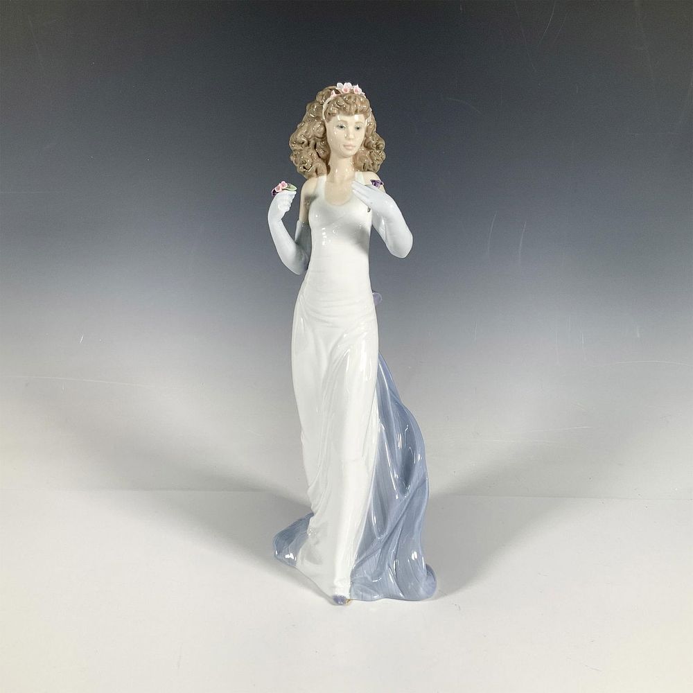 Anticipation 1006608 - Lladro Porcelain Figurine. A glossy figure of a woman in an elegant white 