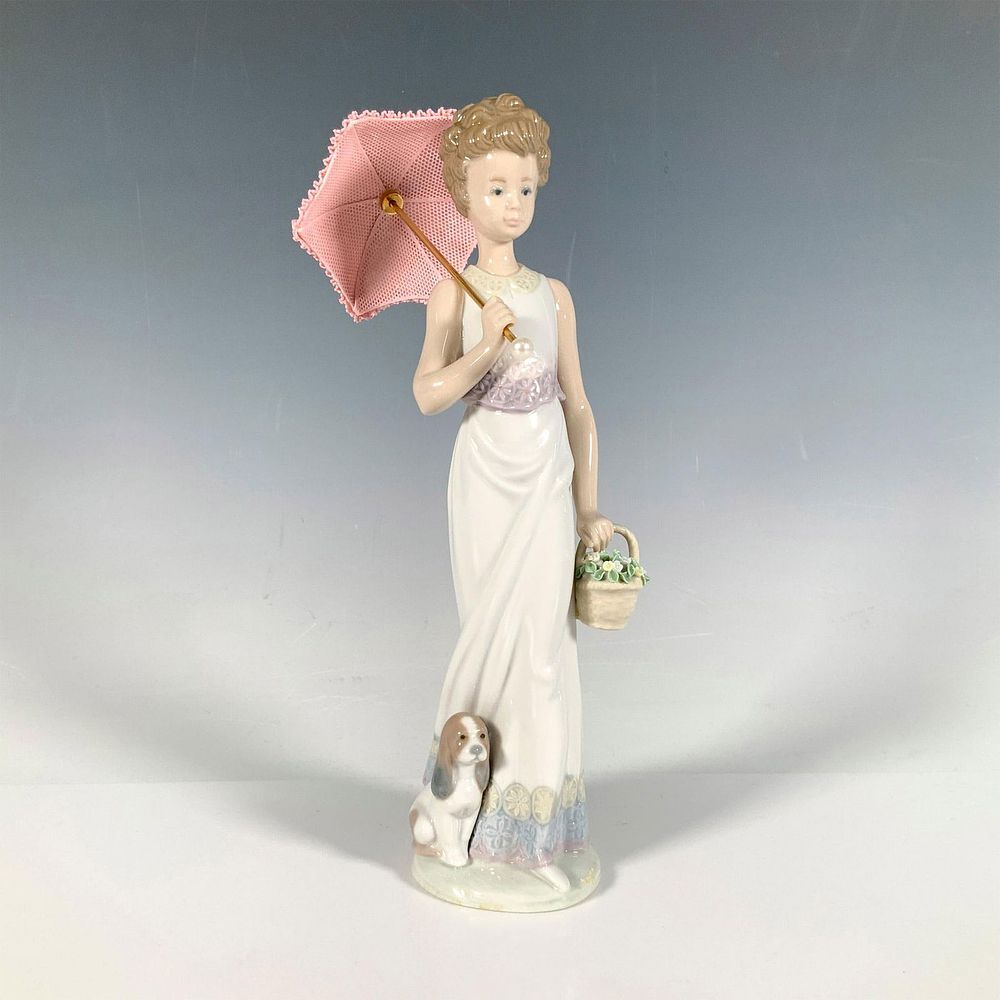 Garden Classic 1007617 - Lladro Porcelain Figurine. Glossy figure of a woman holding a pink 