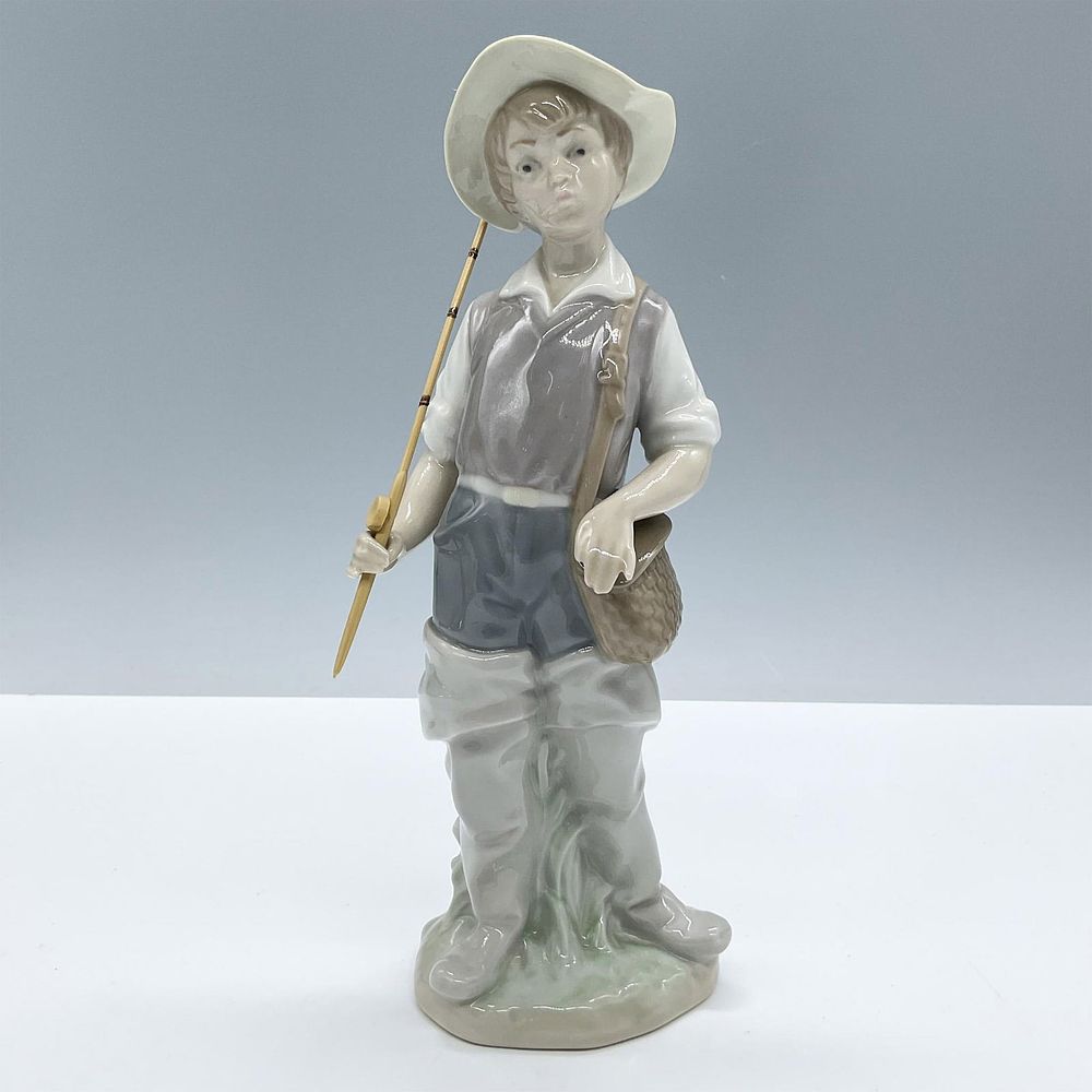 Going Fishing 1004809 - Lladro Porcelain Figurine. Glossy porcelain. Features a cute young boy 