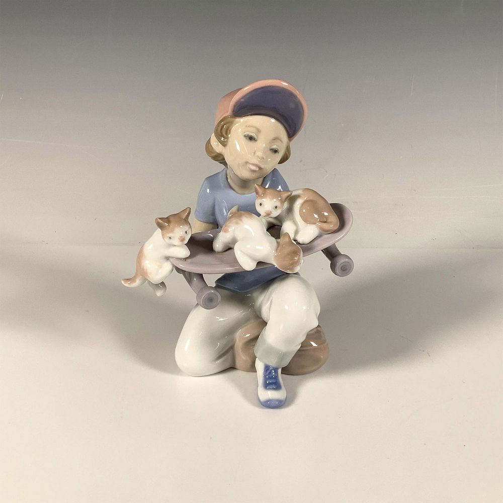 Little Riders 1007623 - Lladro Porcelain Figurine. A glossy figure depicting a young boy holding 