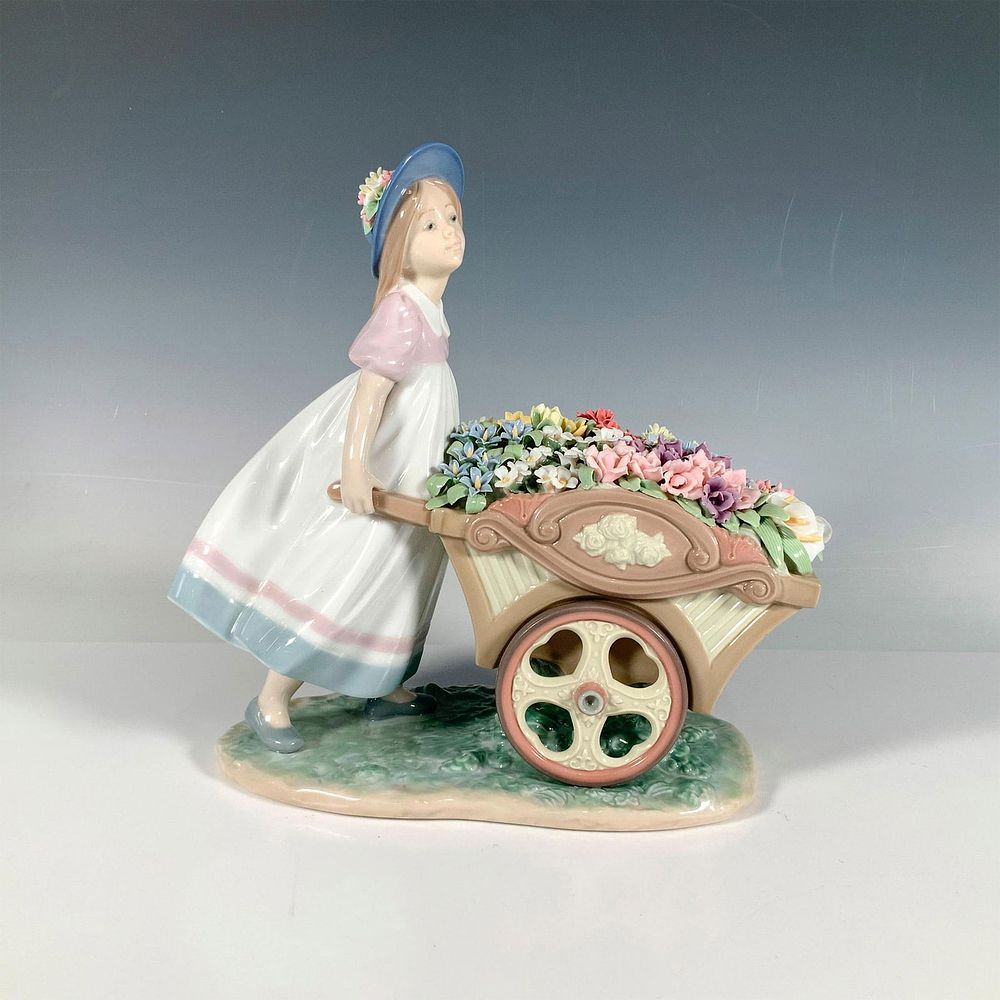 Loves Tender Tokens 1006521 - Lladro Porcelain Figurine. A glossy sculpture of a girl pushing a 