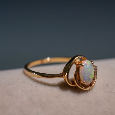10K Gold Opal Ring with Diamond Accent. This delicate ring features an oval-cut opal set in 10K