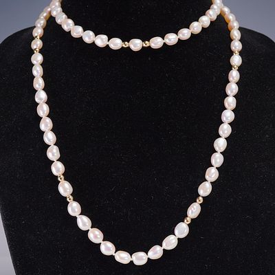 Faux Pearl Necklace with Gold Tone Accents. Long strand of irregular faux pearls in a soft 