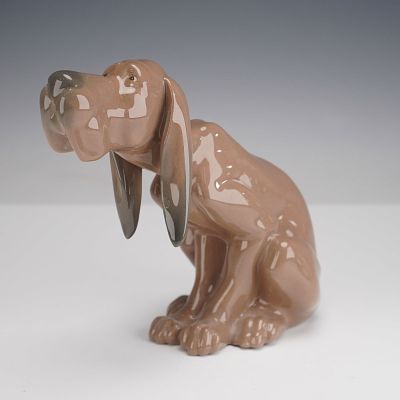 Lladro Porcelain Figurine, Timid Dog 1005111. Modeled as a seated hound with elongated ears and 