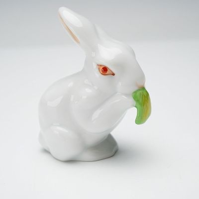 Herend Porcelain Figurine, Bunny Eating. A seated white rabbit holds a green leaf between its 