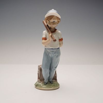 Lladro Porcelain Figurine, Can I Play 1007610. Glossy finish depicting a young boy dressed as a 