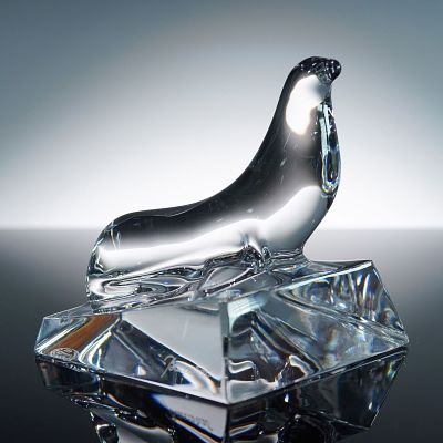 Baccarat Crystal Figurine, Seal. A sculptural crystal seal poised atop a sharply faceted base 