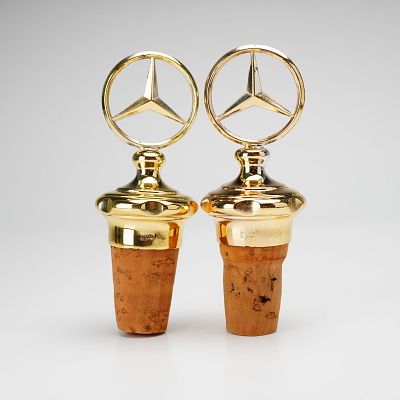 Pair of Mercedes Benz Gold-Tone Wine Bottle Stoppers. Two gold-toned Mercedes Benz emblem tops 