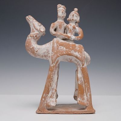 Terracotta Camel with Rider Figurine. This terracotta figurine depicts a camel with two riders 