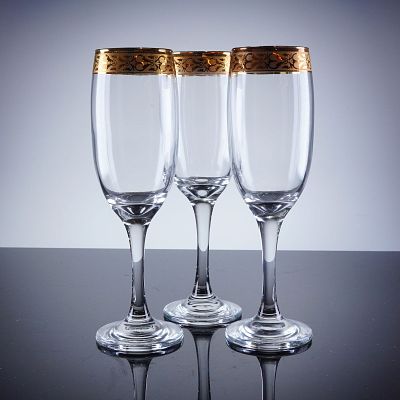 3pc Gold Rim Champagne Flutes. A trio of champagne flutes constructed of clear glass and 