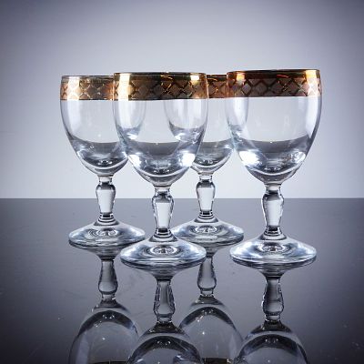 4pc Gold Rim Crystal Wine Glasses. A collection of four crystal wine glasses featuring a plain 