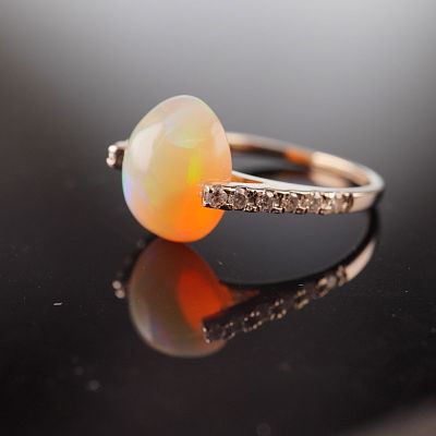 14K Gold 4.23ct Opal and Diamond Ring. A yellow gold ring featuring an oval-shaped opal 