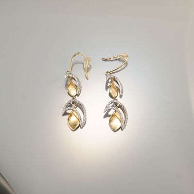 Pair of 14K Two-Tone Gold 0.70ctw Diamond Dangle Earrings. A pair of elegant two-tone dangle 