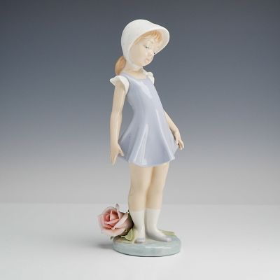 Lladro Porcelain Figurine, Candid 1005039. The figure depicts a young girl standing in a pensive 