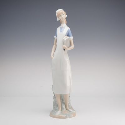 Lladro Porcelain Figurine, Nurse 1004603. Depicting a standing nurse wearing a white cap, blue 