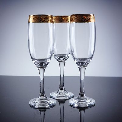 3pc Gold Rim Champagne Flutes. A trio of champagne flutes constructed of clear glass and 