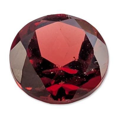 Loose Round Brilliant Cut Red Garnet. Loose faceted red gemstone, appearing to be a natural 