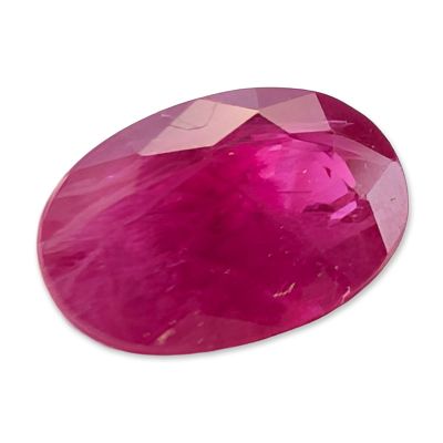 Loose Oval Cut Pinkish Red Ruby. Loose gemstone that appears to be a ruby, featuring an oval 