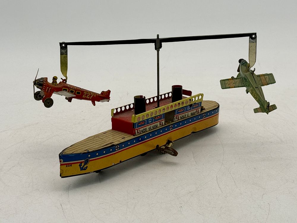 Lot 435: CKO Kellermann Tin Wind-Up Ship with Circling Airplanes